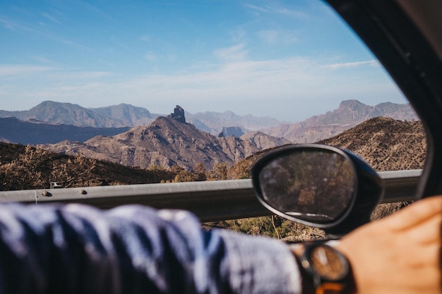 Foto middelsnede van een man die glas tegen bergen vasthoudt