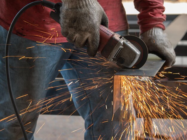 Foto middelsnede van een man die metaal schuift in een fabriek