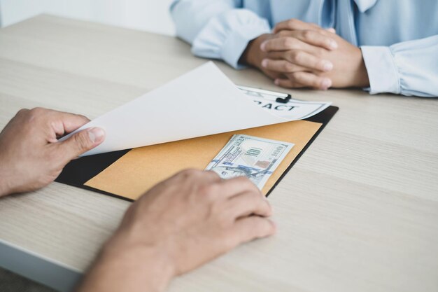 Foto middelsnede van een man die papier vasthoudt terwijl hij op tafel zit