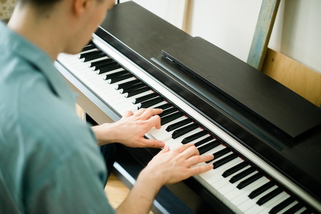 Middelsnede van een man die piano speelt
