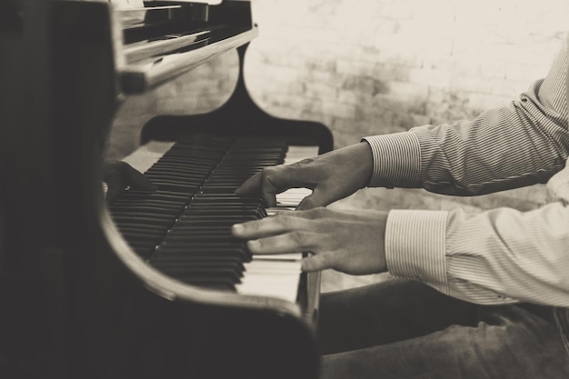 Middelsnede van een man die piano speelt