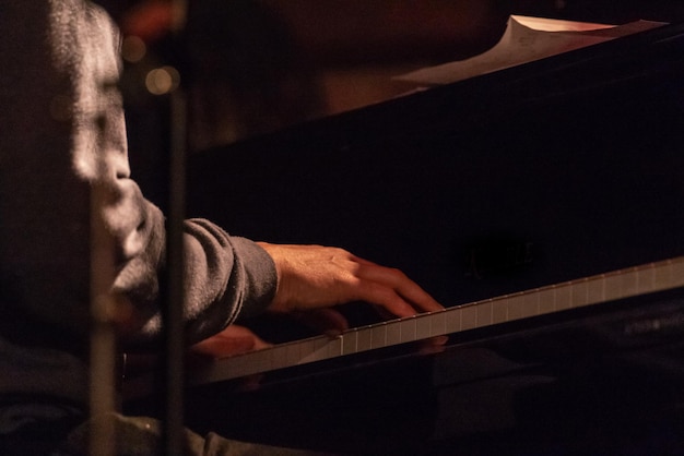 Foto middelsnede van een man die 's nachts piano speelt