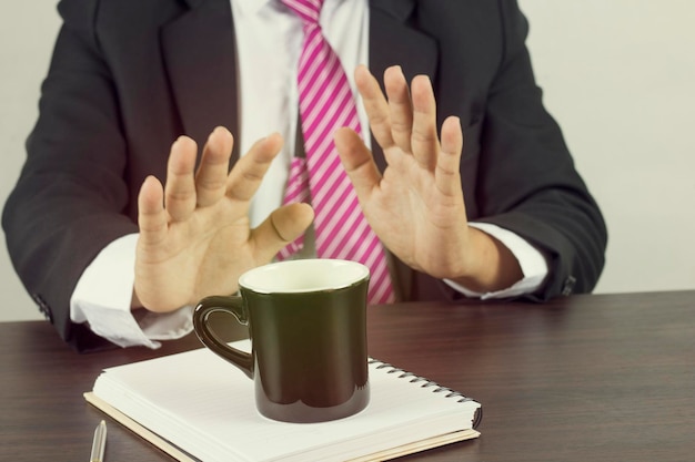 Middelsnede van een man met een koffiekop op tafel