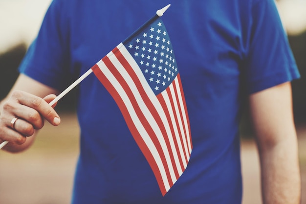 Foto middelsnede van een persoon die de amerikaanse vlag vasthoudt