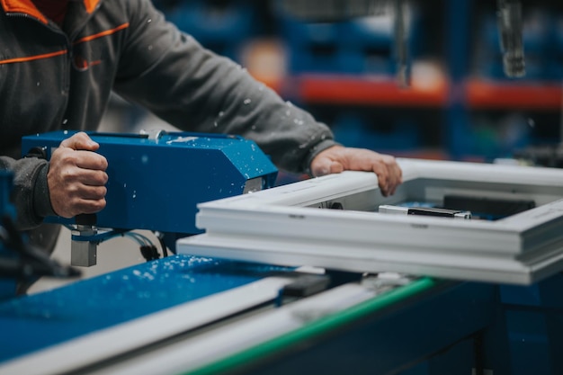 Middelsnede van een volwassen man die apparatuur in een fabriek gebruikt