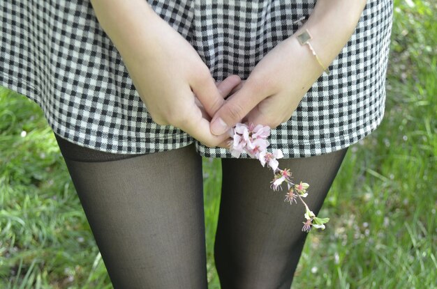 Foto middelsnede van een vrouw die een bloem vasthoudt