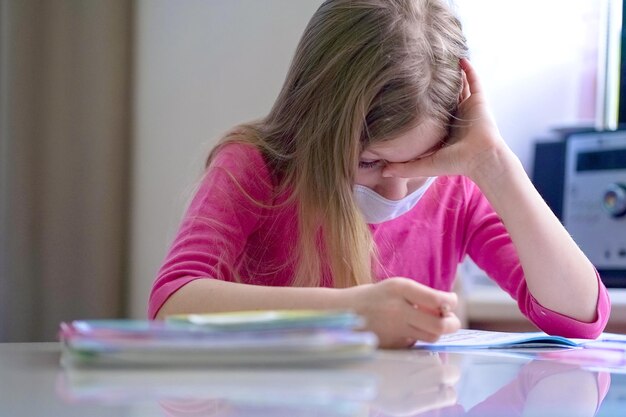 Foto middelsnede van een vrouw die een boek leest terwijl ze op tafel zit