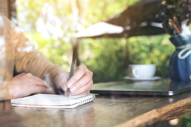 Foto middelsnede van een vrouw die een boek op tafel leest