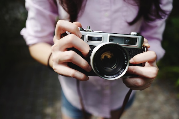 Middelsnede van een vrouw die een camera vasthoudt
