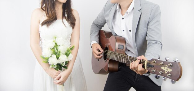 Foto middelsnede van een vrouw die een gitaar vasthoudt terwijl ze tegen de muur staat