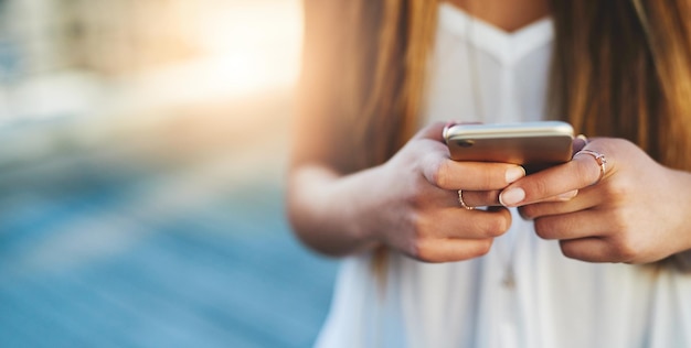 Middelsnede van een vrouw die een mobiele telefoon gebruikt