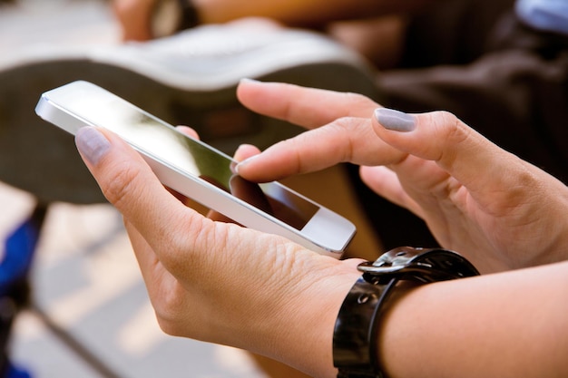 Middelsnede van een vrouw die een mobiele telefoon gebruikt