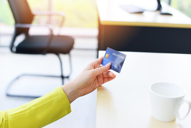 Foto middelsnede van een vrouw die een mobiele telefoon op tafel gebruikt