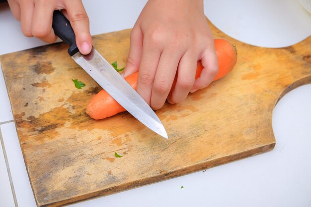 Foto middelsnede van een vrouw die eten bereidt op een snijplank