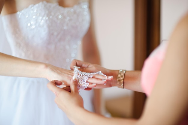 Middelsnede van een vrouw die kant aan de bruid doet
