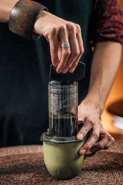 Middelsnede van een vrouw die koffie maakt in een café