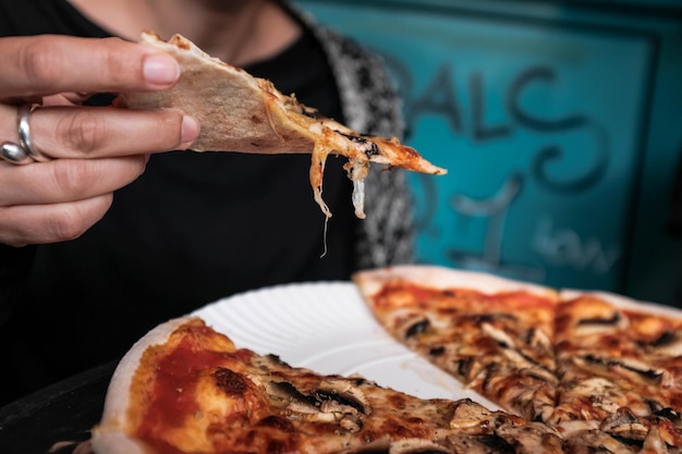 Middelsnede van een vrouw die pizza op een bord heeft