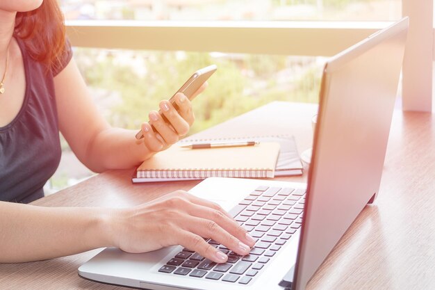 Foto middelsnede van een vrouw die technologieën aan het bureau gebruikt