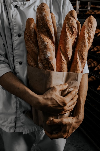 Middelsnede van een vrouw die thuis een baguette vasthoudt