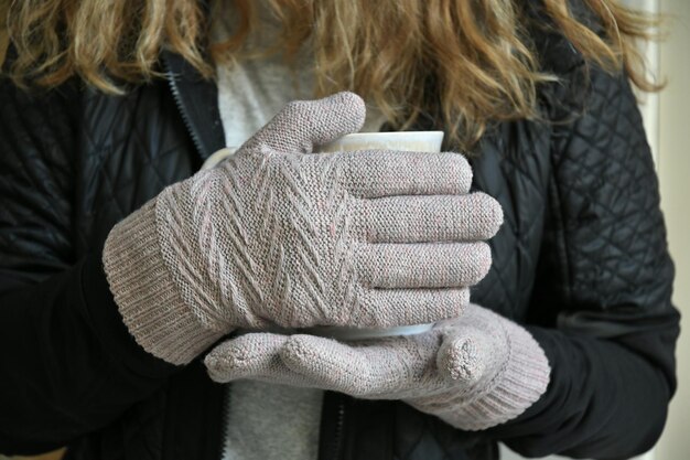 Foto middelsnede van een vrouw die thuis een koffiekopje vasthoudt