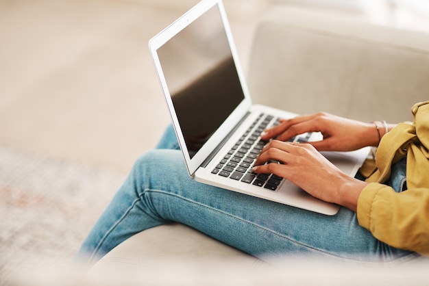 Foto middelsnede van een vrouw die thuis een laptop gebruikt