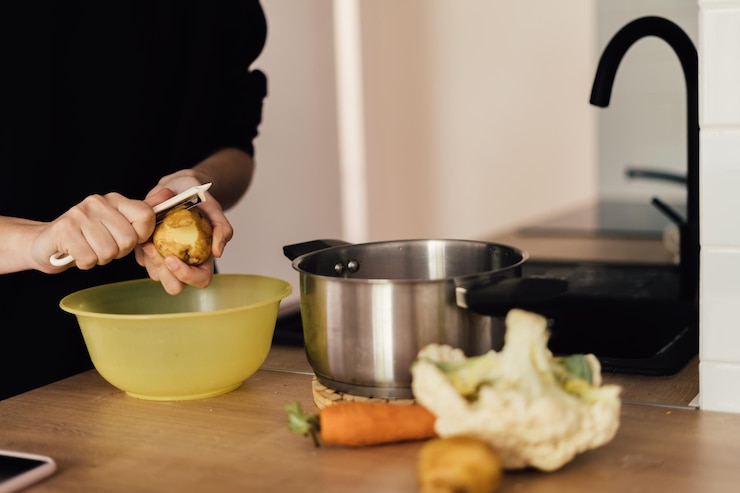 Foto middelsnede van een vrouw die thuis eten bereidt