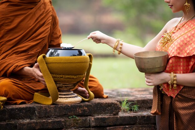 Foto middelsnede van een vrouw in traditionele kleding die buiten bidt als monnik