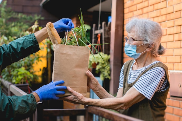 Middelsnede van een vrouw met een paraplu terwijl ze tegen planten in de tuin staat
