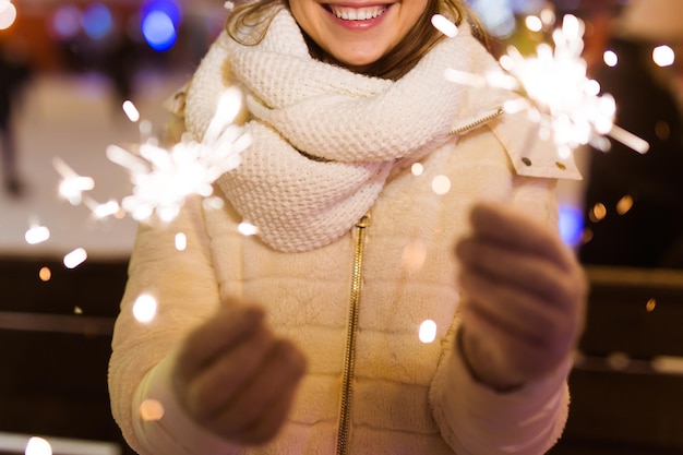 Foto middelsnede van een vrouw met een verlichte kerstboom in de winter