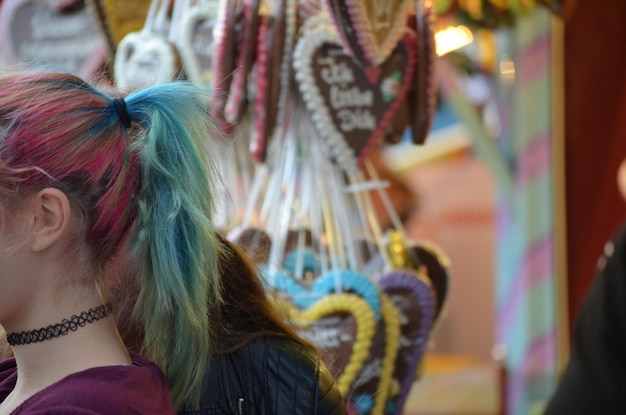 Foto middelsnede van een vrouw met gekleurd haar die op de markt staat