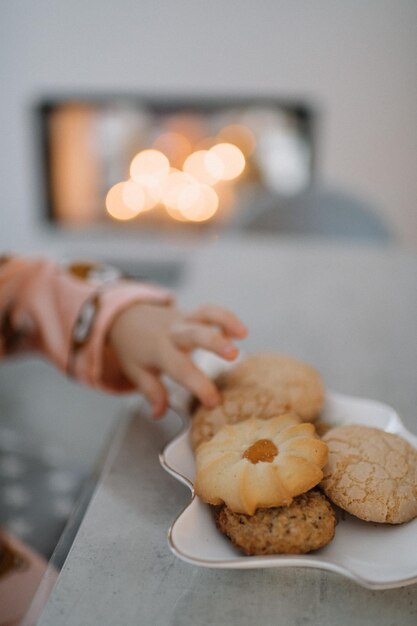 Middelsnede van een vrouw met koekjes op tafel thuis