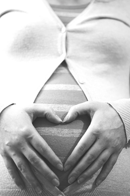 Middelsnede van een zwangere vrouw die de buik raakt
