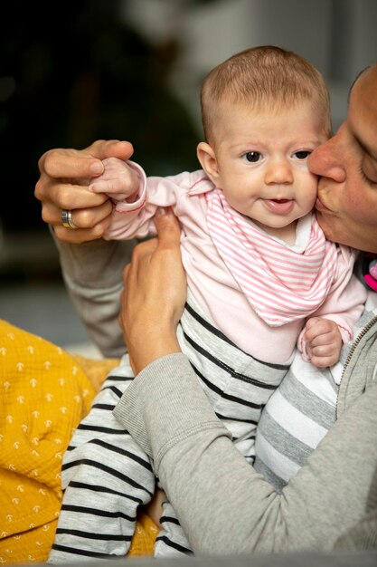 Middelsnede van moeder die zoent terwijl ze baby houdt