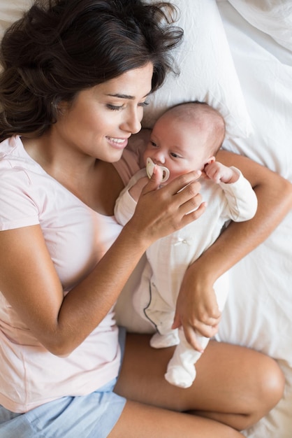 Middelsnede van moeder en dochter baby op bed