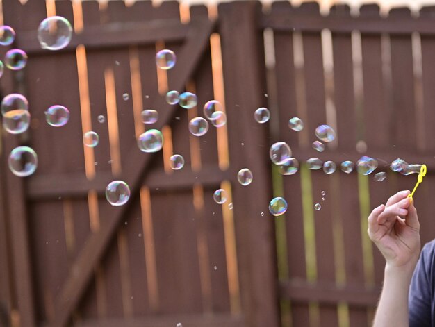 Foto middelsnede van persoon die bubbels in bubbels houdt