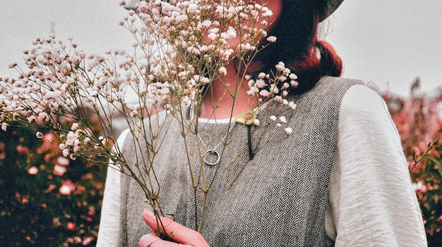 Foto middelsnede van vrouw die bloemen vasthoudt