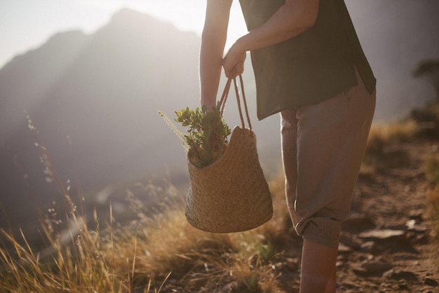 Middelsnede van vrouw met tas die op het land staat