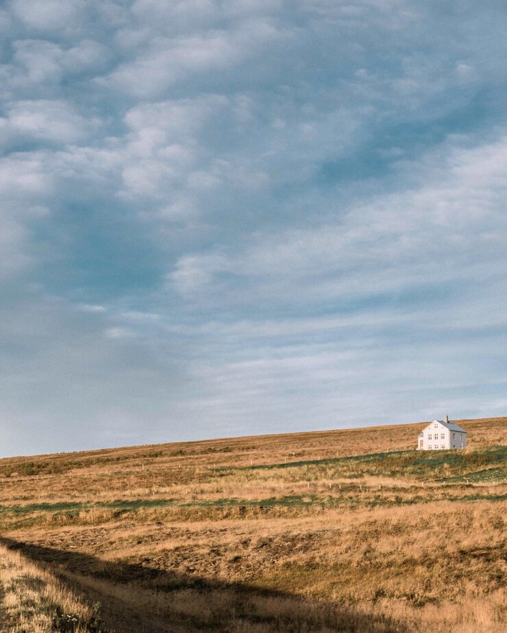 Foto midden afstandsbeeld van het huis op het veld tegen de lucht