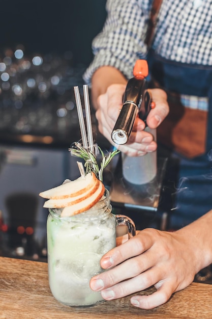 Midden gedeelte van een man die een cocktail bereidt