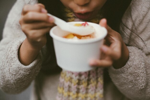 Foto midden sectie van meisje dat dessert eet