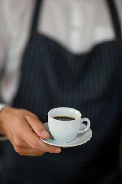 Middengedeelte van ober die zich met kop van koffie bevindt