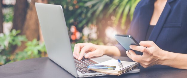 Middensectie van een vrouw die een mobiele telefoon gebruikt