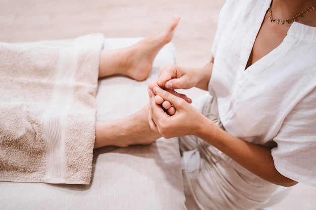 Foto middensectie van therapeut die een vrouw masseert in de spa