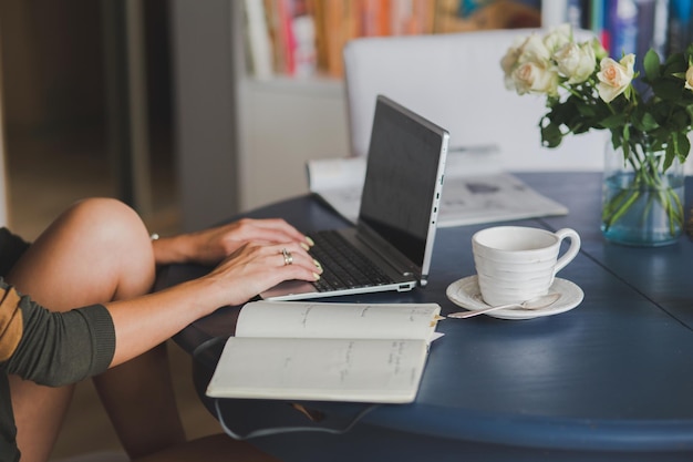 Middensectie van vrouw met laptop aan tafel