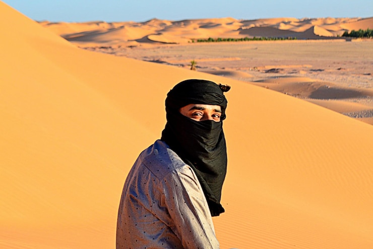 Foto middenvolwassen man in de woestijn tegen de lucht