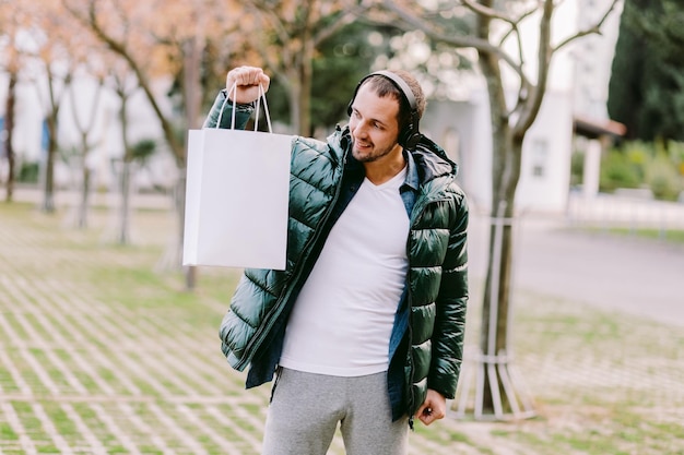Foto middenvolwassen man met een tas die naar buiten kijkt terwijl hij buiten staat