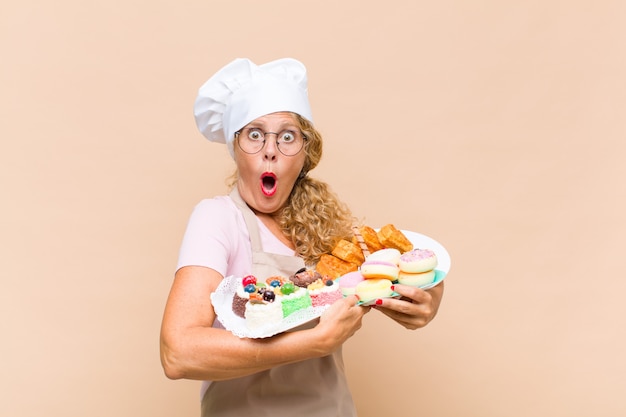 Middle age baker woman with cakes