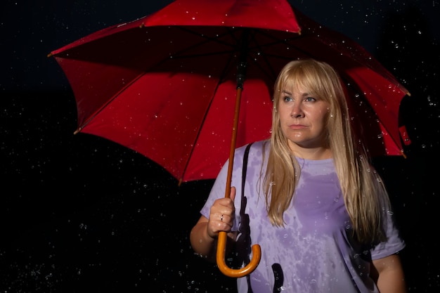 Middle age blonde woman under red umbrella