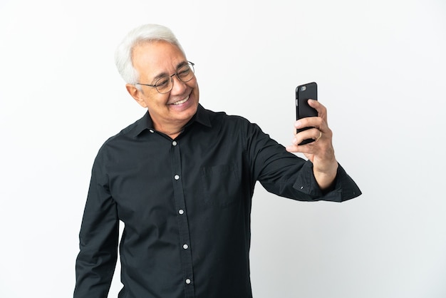 Middle age Brazilian man isolated on white background making a selfie