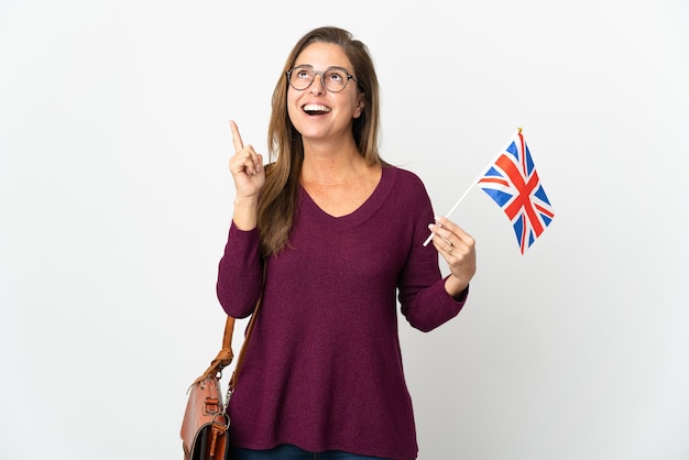 Middle age  Brazilian woman holding an United Kingdom flag isolated on white thinking an idea pointing the finger up